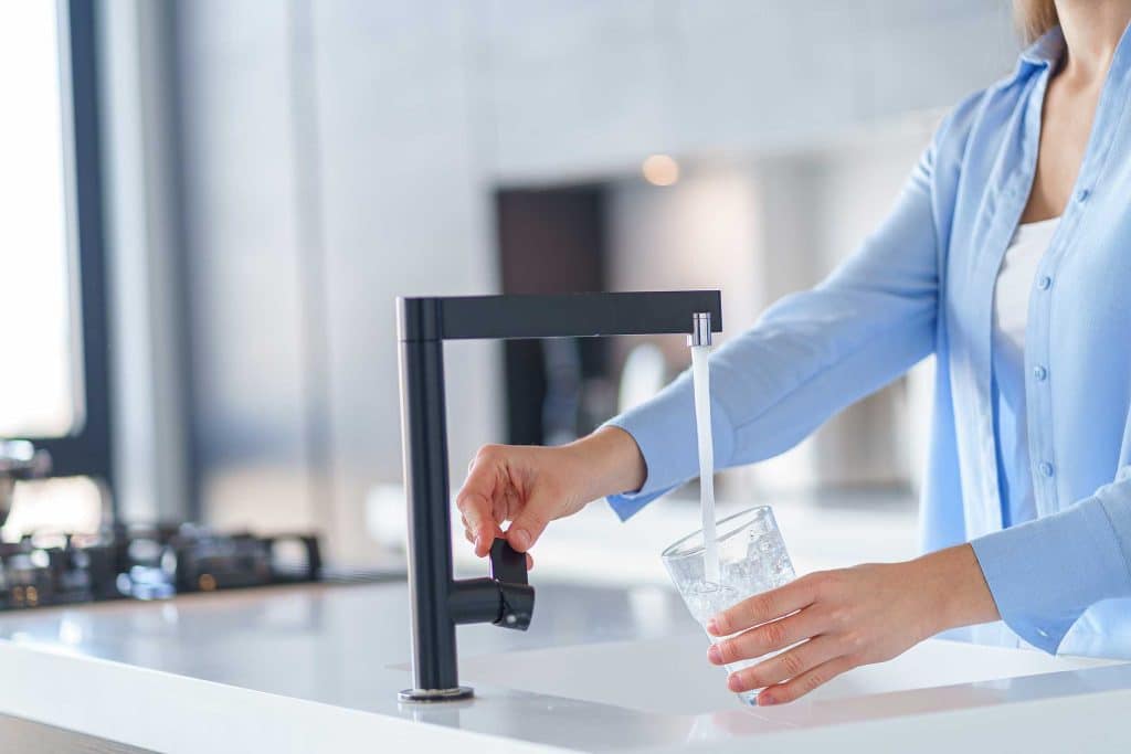 Moderner Wasserhahn aus dem gerade Wasser fließt